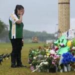 A teen visits a memorial to the shooting victims at Santa Fe High School in Texas.