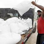 Travis Lee loaded sand bags onto a truck bed on Saturday in Gulfport, Miss. 
