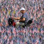 Boston, MA - 05/23/18 - Oscar Borraro (cq) rode his chair through a field of thousands of American flags. His father served in the army. Hundreds of volunteers planted flags in Boston Common for Memorial Day to honor the roughly 37,000 Massachusetts service personnel who have given their lives since the Revolutionary War. (Lane Turner/Globe Staff) Reporter: (in caps) Topic: (24flaggarden)