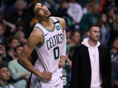 Boston, MA: 5-27-18: The Celtics Jayson Tatum is pictured reacting as the final seconds tick off the game clock, injured teammate Gordon Hayward is in the backround at right. The Boston Celtics hosted the Cleveland Cavaliers for Game Seven of their NBA Eastern Conference Finals playoff series at the TD Garden. (Jim Davis/Globe Staff)
