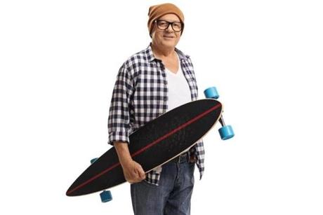 Old hipster holding a longboard isolated on white background
