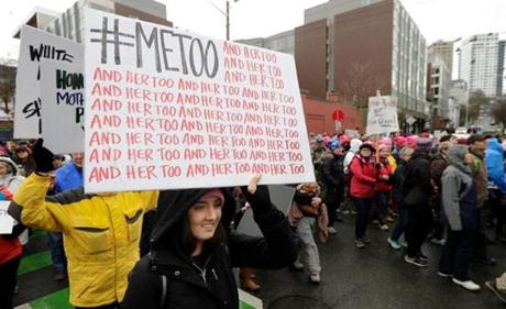 FILE - In this Saturday, Jan. 20, 2018 file photo, a marcher carries a sign with the popular Twitter hashtag #MeToo used by people speaking out against sexual harassment as she takes part in a Women's March in Seattle, on the anniversary of President Donald Trump's inauguration. Six months after bursting into the spotlight, the #MeToo movement has toppled scores of men from prominent positions and fueled a national conversation about workplace sexual harassment. Questions abound about the movement's staying power, but there's ample evidence that its impact will be durable. (AP Photo/Ted S. Warren)
