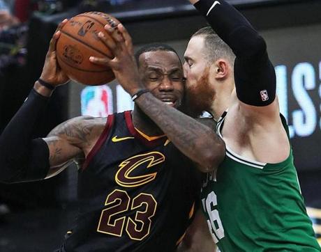 The Celtics? Aron Baynes (right) gets up close and personal with the Cavaliers? LeBron James on a second-half drive to the hoop during a game in Cleveland..
