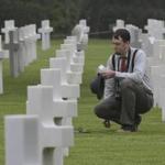 Matthew Conway of Burlington, Conn., put a flower on the grave of his uncle, John J. Ketter, at the Colleville American military cemetery in western France Wednesday. 