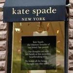 A sign hangs in the window of the Kate Spade store on Newbury Street.