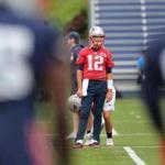 Foxborough- 06/05/18- The Patriots held a minicamp at the Gillette Stadium practice facility. QB Tom Brady is framed through players as he pauses during warmups. Photo by John Tlumacki/Globe Staff(sports)