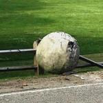 One of the spheres that was part of an art installation at Larz Anderson Park in Brookline lays damaged against a fence.  ? 