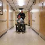 Nick Bonanno pushed his father, Russ Bonanno, down the hallway at the VA in Bedford. The facility is one of four run by the VA that lagged private nursing home averages on 10 of 11 quality indicators. 