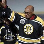 Former Boston Bruins wing Willie O'Ree tips his hat as he is honored prior to the first period of an NHL hockey game against the Montreal Canadiens in Boston, Wednesday, Jan. 17, 2018. O'Ree broke the NHL's color barrier 60 years ago while playing a game against the Canadiens in 1958. (AP Photo/Charles Krupa)