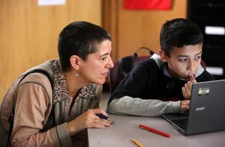 Boston, MA--10/15/2015--EdVestors (cq) president and CEO Laura Perille (cq) looks in on 12-year-old sixth-grader David Iovanna (cq). Students at TechBoston Academy use technology, from EdVestors, to learn math on Thursday, October 15, 2015. Photo by Pat Greenhouse/Globe Staff Topic: 19edvestors Reporter: Jeremy Fox
