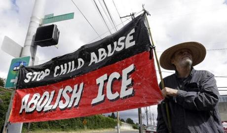 A man held a sign at a protest camp on property outside the US Immigration and Customs Enforcement office in Portland, Ore., on Monday. The round-the-clock demonstration outside the Portland facility began June 17. 
