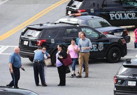 People walk from the direction of the Capital Gazette building, where five people were fatally shot Thursday in Annapolis, Maryland. MUST CREDIT: Washington Post photo by Matt McClain
