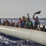 Migrants aboard a rubber dinghy off the Libyan coast waved to rescuers aboard the Open Arms aid boat Saturday.