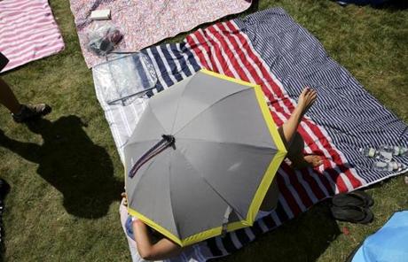SLIDER--Tanya Matthews of Augusta, GA, protects herself from the sun while waiting for the Boston Pops Fireworks Spectacular to begin at the Hatch Shell on the Esplanade in Boston, MA on July 04, 2018. (Craig F. Walker/Globe Staff) section: metro reporter:
