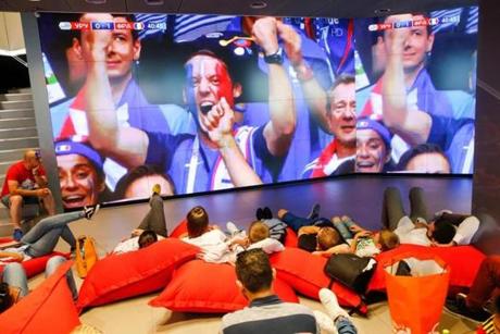 People in Moscow watched a giant screen showing French supporters cheering after France scored during the Russia 2018 World Cup quarter-final football match between Uruguay and France.
