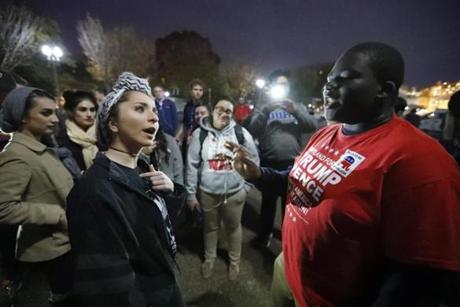 Meriem Palesty, left, from Washington, a Muslim woman of Syrian descent, argues her point with Samuel Tebi, from Gaithersburg, Md., a supporter of President-elect Donald Trump, during an election protest in front of the White House, Friday, Nov. 11, 2016 in Washington. (AP Photo/Alex Brandon)
