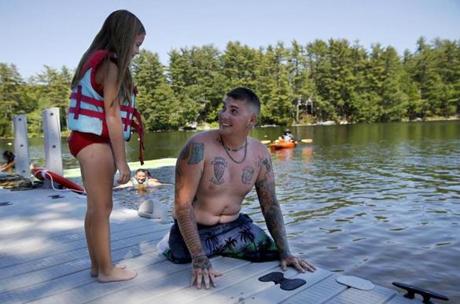 Rome, ME--6/26/2018-- Brandon Long, a Marine who lost both of his legs while serving in Afghanistan looks back at his daughter, Claire, 7, right before she pushes him into Long Pond as the two play by the waterfront at the Travis Mills Retreat. (Jessica Rinaldi/Globe Staff) Topic: 01maine Reporter: Brian MacQuarrie
