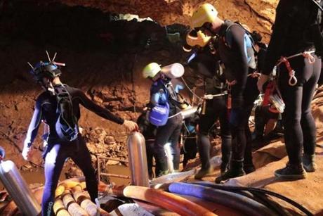 In this undated photo released by Royal Thai Navy on Saturday, July 7, 2018, Thai rescue team members walk inside a cave where 12 boys and their soccer coach have been trapped since June 23, in Mae Sai, Chiang Rai province, northern Thailand. The local governor in charge of the mission to rescue them said Saturday that cooperating weather and falling water levels over the last few days had created appropriate conditions for evacuation, but that they won't last if it rains again. (Royal Thai Navy via AP)
