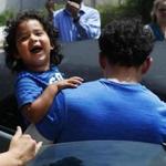 Ever Reyes Mejia, of Honduras, carried his son to a vehicle after being reunited in Grand Rapids, Mich., on Tuesday.