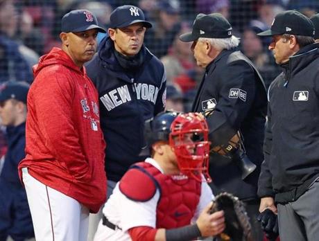 Boston, MA: 4/9/2018: Managers Alex Cora of the Red Sox and Aaron Boone of the Yankees meet with the umpires at home plate before the start of the game. The Boston Red Sox hosted the New York Yankees in a regular season MLB baseball game at Fenway Park. (Jim Davis/Globe Staff)
