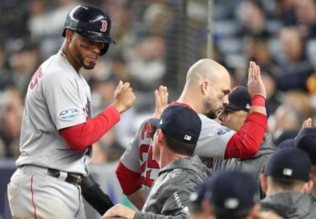 New York 10/08/18: Red Sox Xander Bogaerts and Steve Pearce give high fives to teammates after scoring in the fourth inning. New York Yankees hosted the Boston Red Sox in game three of the ALDS at Yankee Stadium Monday, Oct. 8, 2018. (Jim Davis/Globe Staff)
