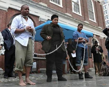 Kevin Peterson (left), Celestina Crenshaw, and Avonte Dabney portrayed slaves during?s Saturday?s reenactment at Faneuil Hall.
