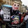 A man dressed up as the movie character 'the joker' with the hair style of the US President Donald Trump, holds a sign during an protest against the US leader at the Place de la Republique in central Paris on November 11, 2018, as leaders from around the world, including Trump, gathered in the French capital to mark the 100th anniversary of the 11 November 1918, World War I, armistice. (Photo by STRINGER / AFP)STRINGER/AFP/Getty Images