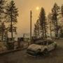 As the Camp Fire burns nearby, a scorched car rests by gas pumps near Pulga, Calif., on Sunday, Nov. 11, 2018. (AP Photo/Noah Berger)