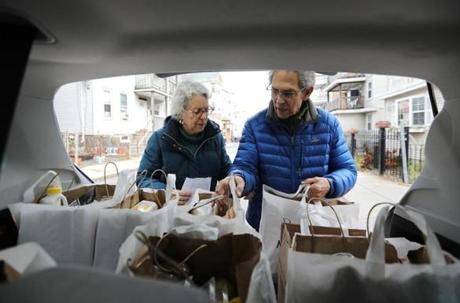 Sharryn Ross and Jon Truslow took a food order from the back of the family vehicle. The couple has been volunteering at Community Servings for more than two decades, delivering meals to people in need in the Boston area.
