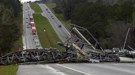 A fallen cell tower lies across U.S. Route 280 highway in Lee County, Ala., in the Smiths Station community after what appeared to be a tornado struck in the area Sunday, March 3, 2019. Severe storms destroyed mobile homes, snapped trees and left a trail of destruction amid weather warnings extending into Georgia, Florida and South Carolina, authorities said. (Mike Haskey/Ledger-Enquirer via AP)
