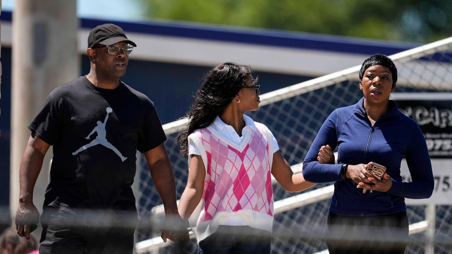 Parents walked their child out of Apalachee High School after a shooting at the school Wednesday, Sept. 4, in Winder, Ga.