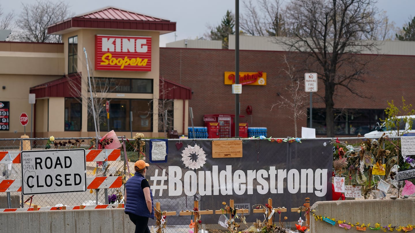 Tributes cover the temporary fence around the King Soopers grocery store in which 10 people died in a mass shooting, on April 23, 2021, in Boulder, Colo.