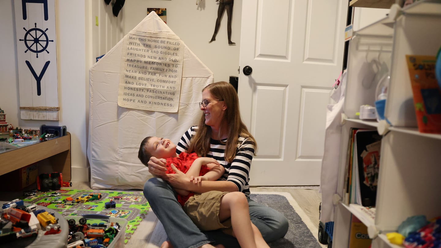 Perry Baker embraced her 7-year-old son, Ezra, as they played together in their living room. Ezra has multiple disabilities, including a speech delay.