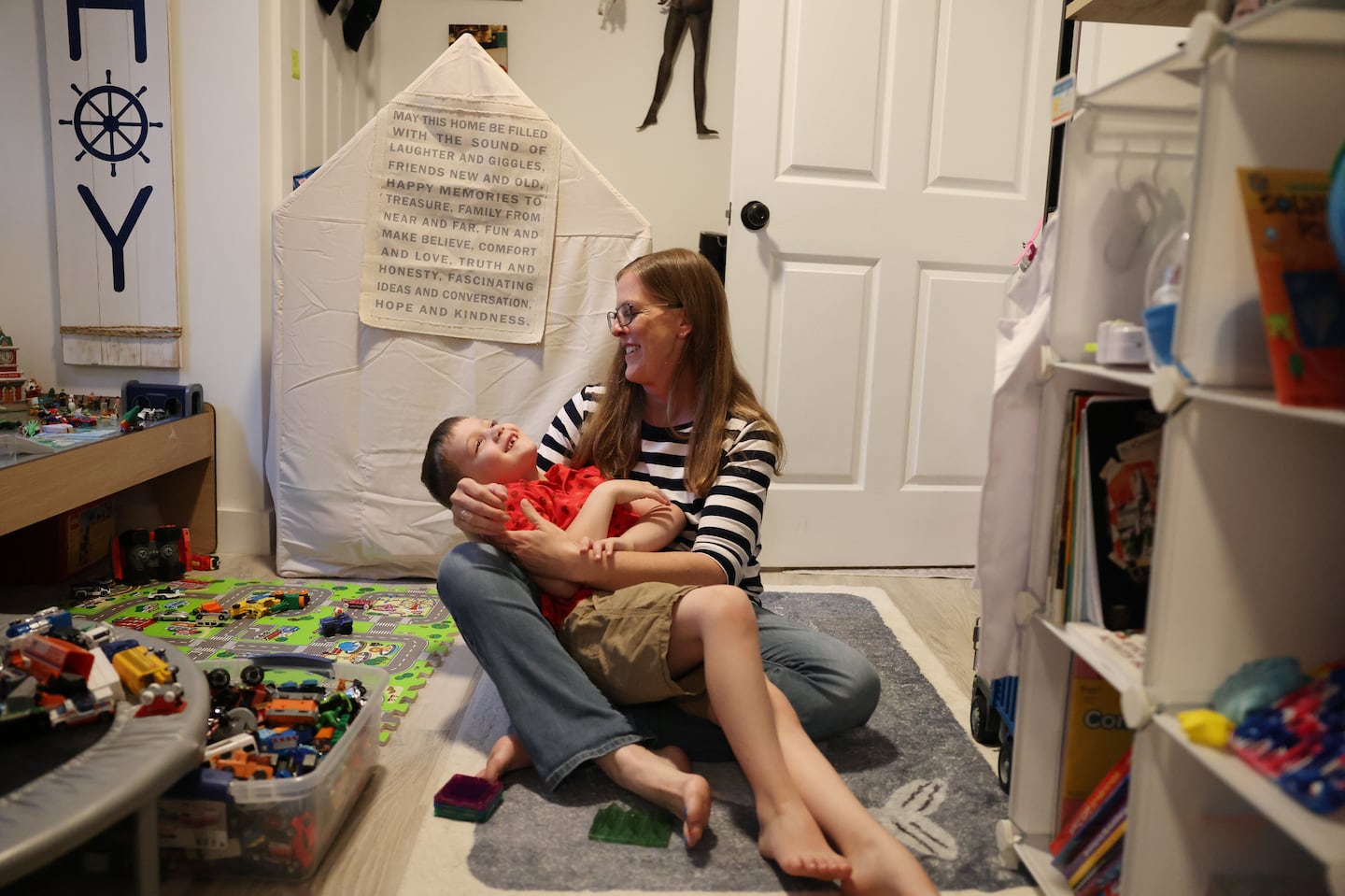 Perry Baker embraced her 7-year-old son, Ezra, as they played together in their living room. Ezra has multiple disabilities, including a speech delay.