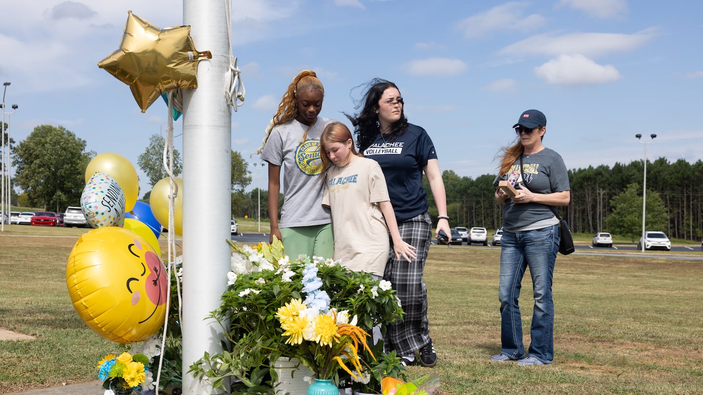 Students placed flowers and balloons at a makeshift memorial at Apalachee High School on Thursday in Winder, Ga.