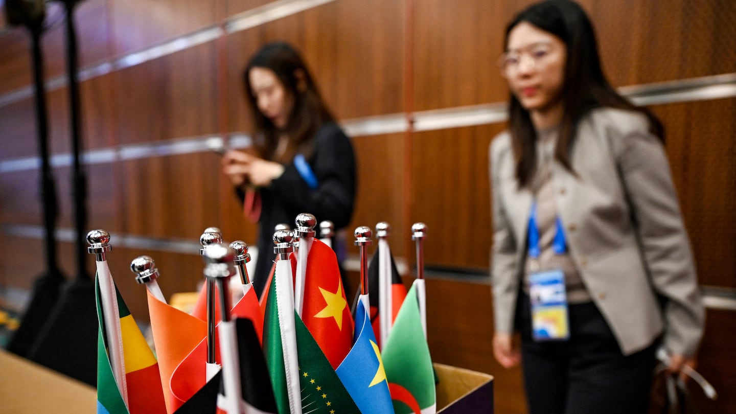 Workers stood behind a box with national flags of African nations during a press conference led by China's foreign minister Wang Yi and his counterparts, Senegal's Yassine Fall and Congo's Jean-Claude Gakosso, at the Forum on China-Africa Cooperation in Beijing on Thursday.