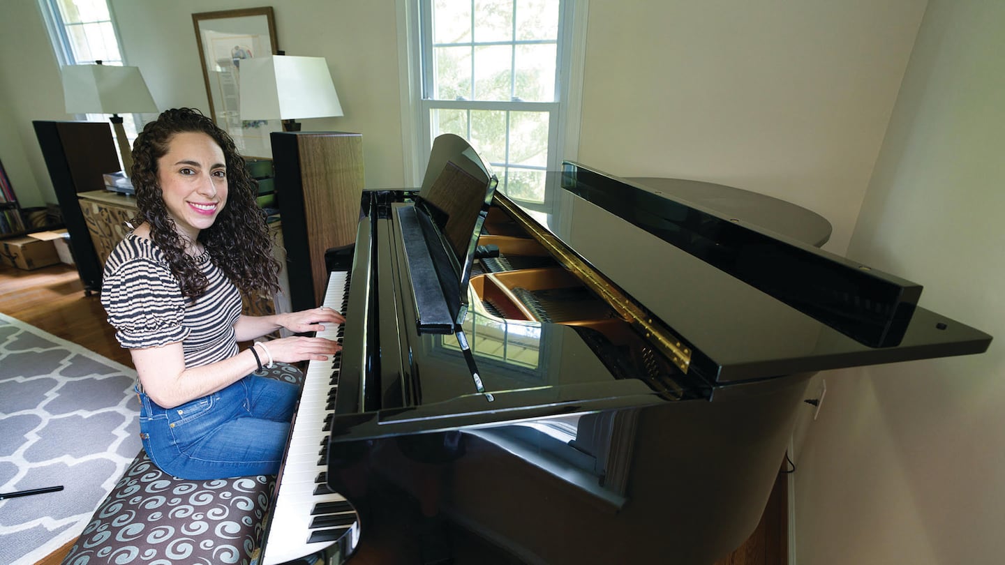 The writer playing her “new” second-hand piano.