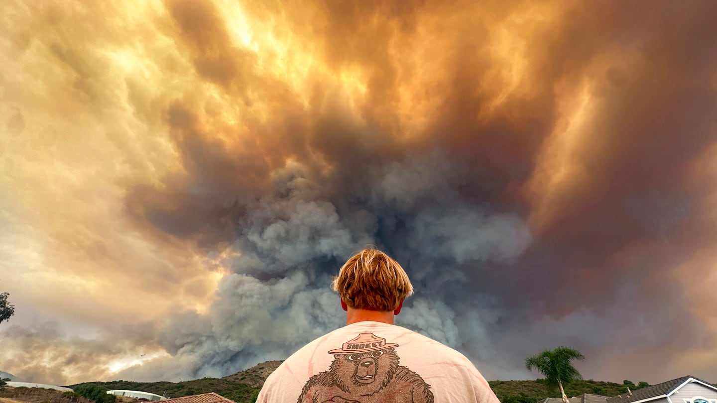 Aidan Thomas watches smoke from the Airport Fire rise behind Meander Lane in Trabuco Canyon, Calif., on Sept. 9.