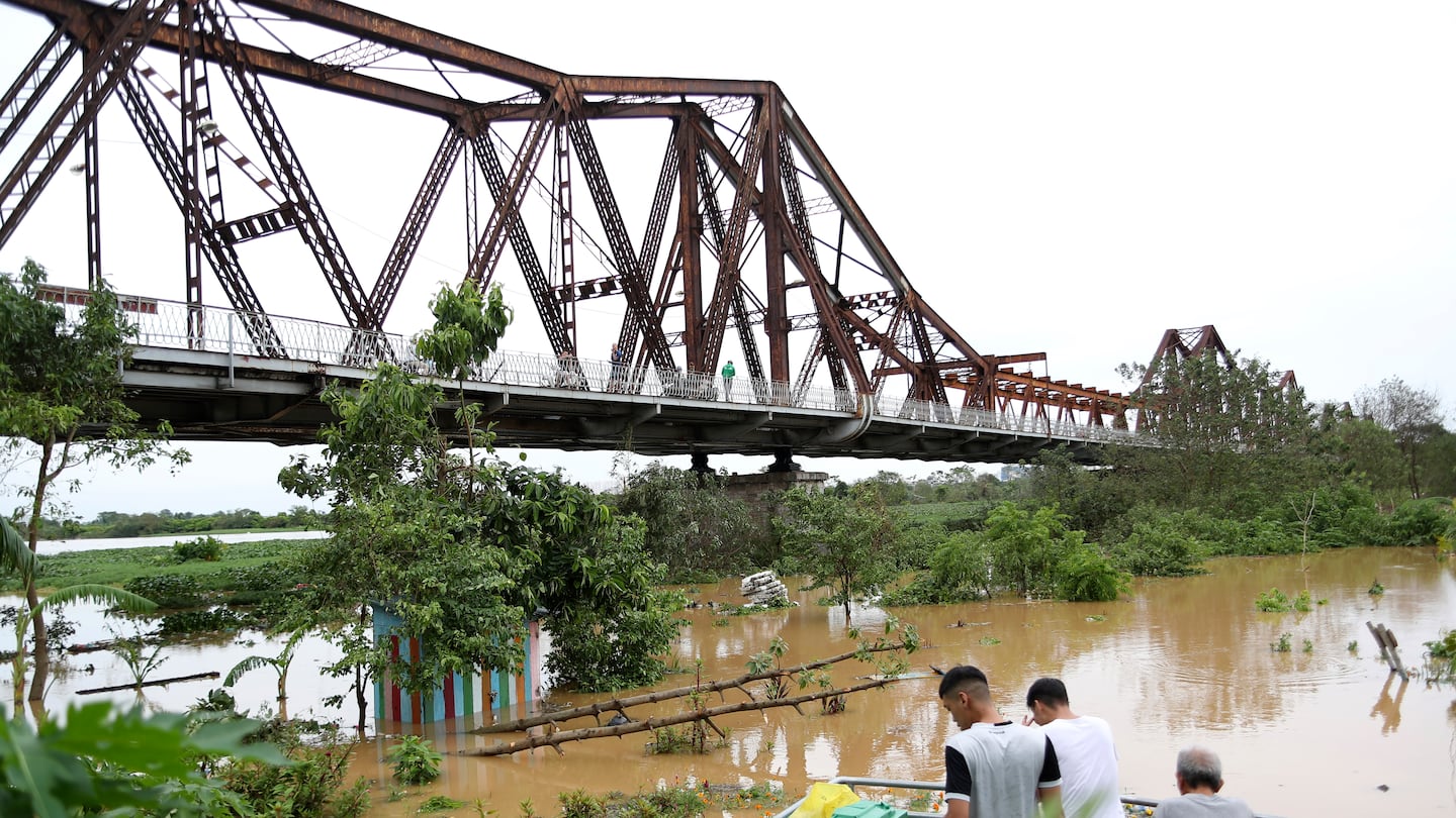 People watch the flooded Red river next to iconic Long Bien bridge, following Typhoon Yagi in Hanoi, Vietnam on Tuesday.