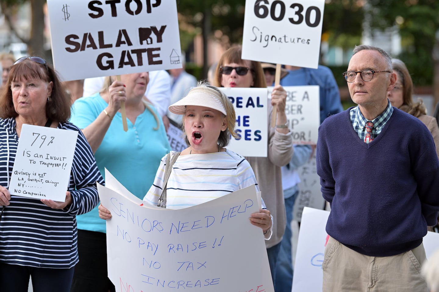 Sheila Chan, center, participated in a demonstration by a group called "A Just Quincy" at City Hall Plaza in Quincy, protesting against the raises of the mayor and councilors.