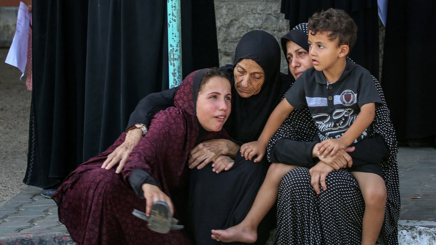 Women and children gathered during the funeral Thursday of a man killed by Israeli bombardment on Al-Jaouni School in central Gaza Strip the previous day.