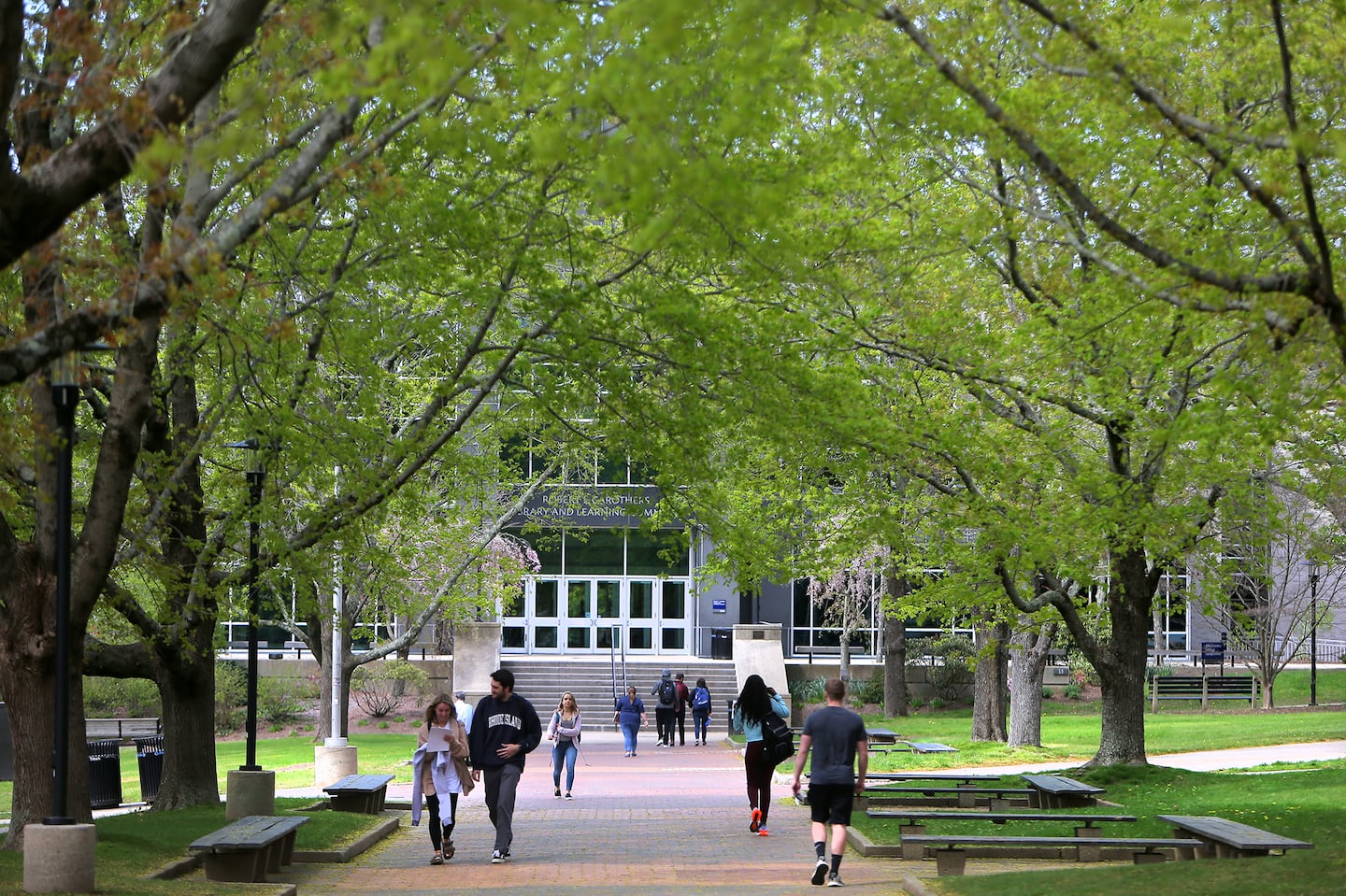 People walk along the Dieter Hammerschlag Mall on the campus of the University of Rhode Island in Kingston, R.I.