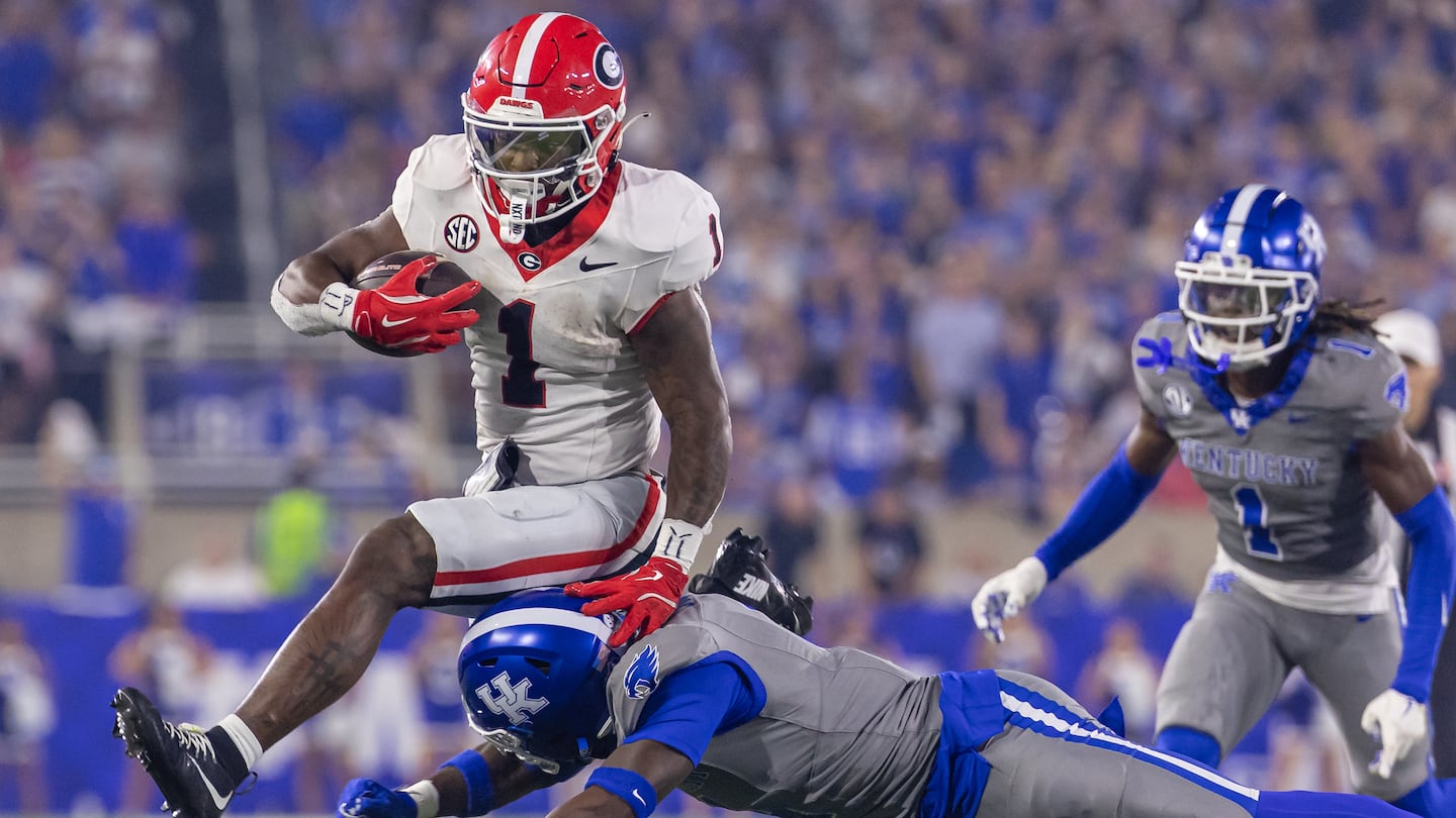 Georgia's Trevor Etienne leaps to avoid the tackle from Kentucky's Kristian Story to help set up the Bulldogs' only touchdown of Saturday night's 13-12 victory.