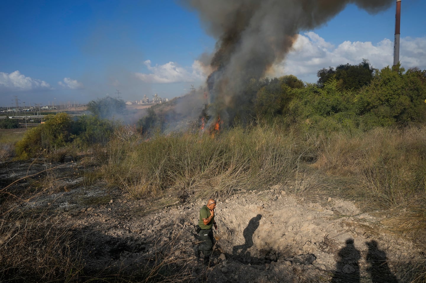 A police officer inspects the area around a fire after the military said it fired interceptors at a missile launched from Yemen that landed in central Israel on Sept. 15.