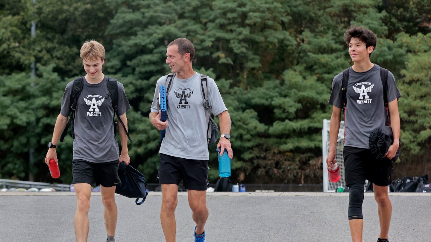 Flanked by top runners Sam Davis (left) and Daichi Collins (right), Arlington cross-country coach Kevin Richardson is confident the Spy Ponders have the proper balance to make a deep run.