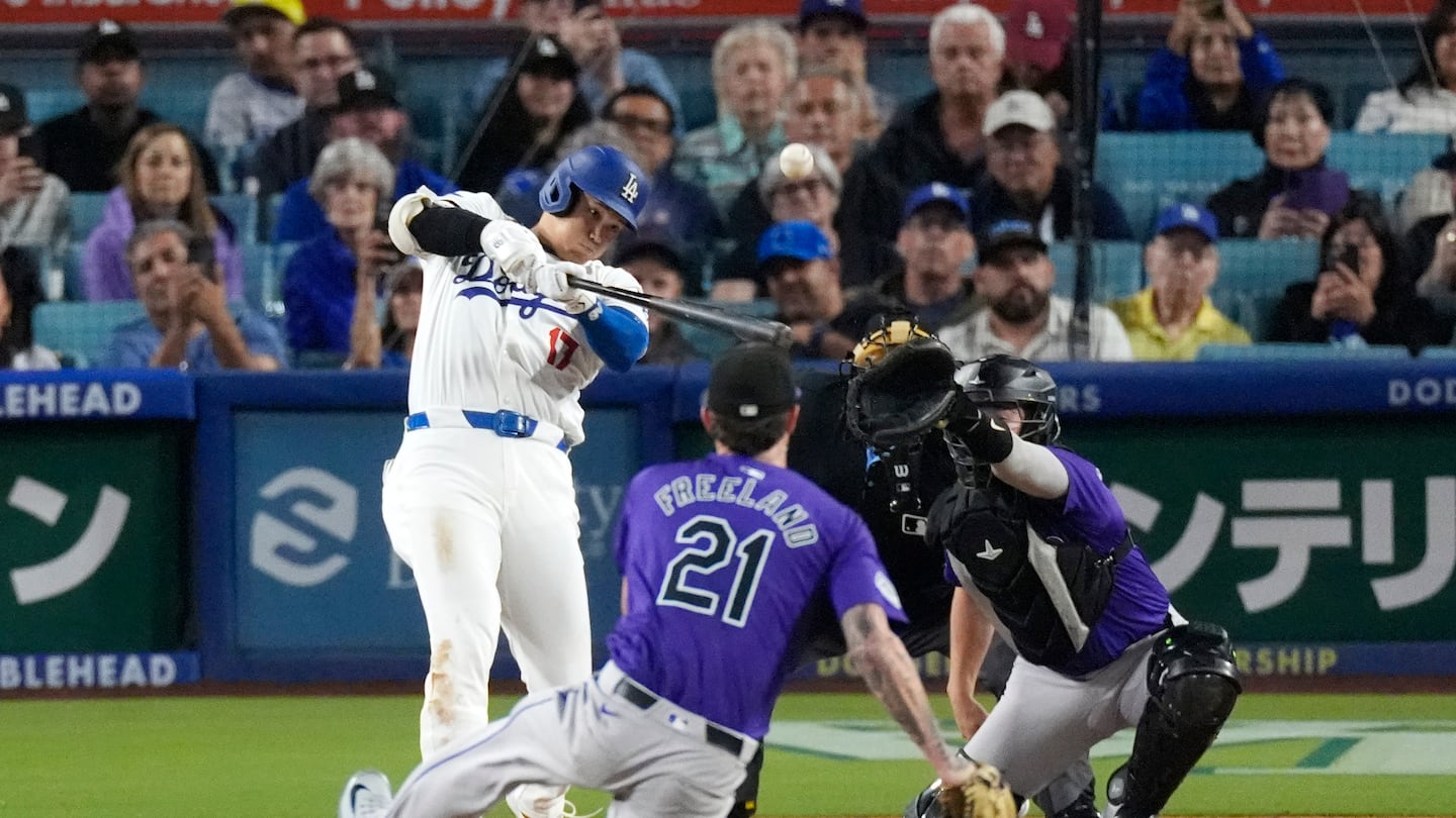 Shohei Ohtani goes upstairs to rocket a high fastball out for a two-run homer, his 52nd of the season, against Rockies starter Kyle Freeland in the fifth inning Friday night in Los Angeles.