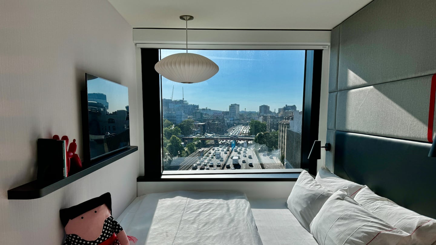 A bed in the new citizenM Back Bay Boston hotel with a view of the Massachusetts Turnpike below.