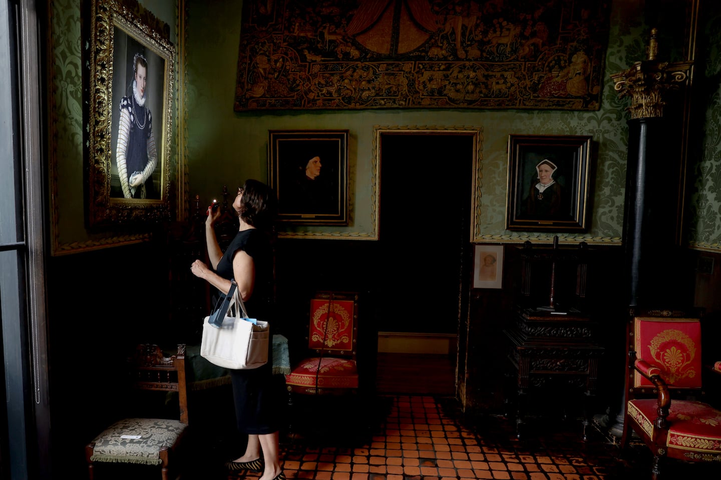 Lucia Bay, associate paintings conservator at the Isabella Stewart Gardner Museum, looking at a painting with her flashlight in the Dutch Room.