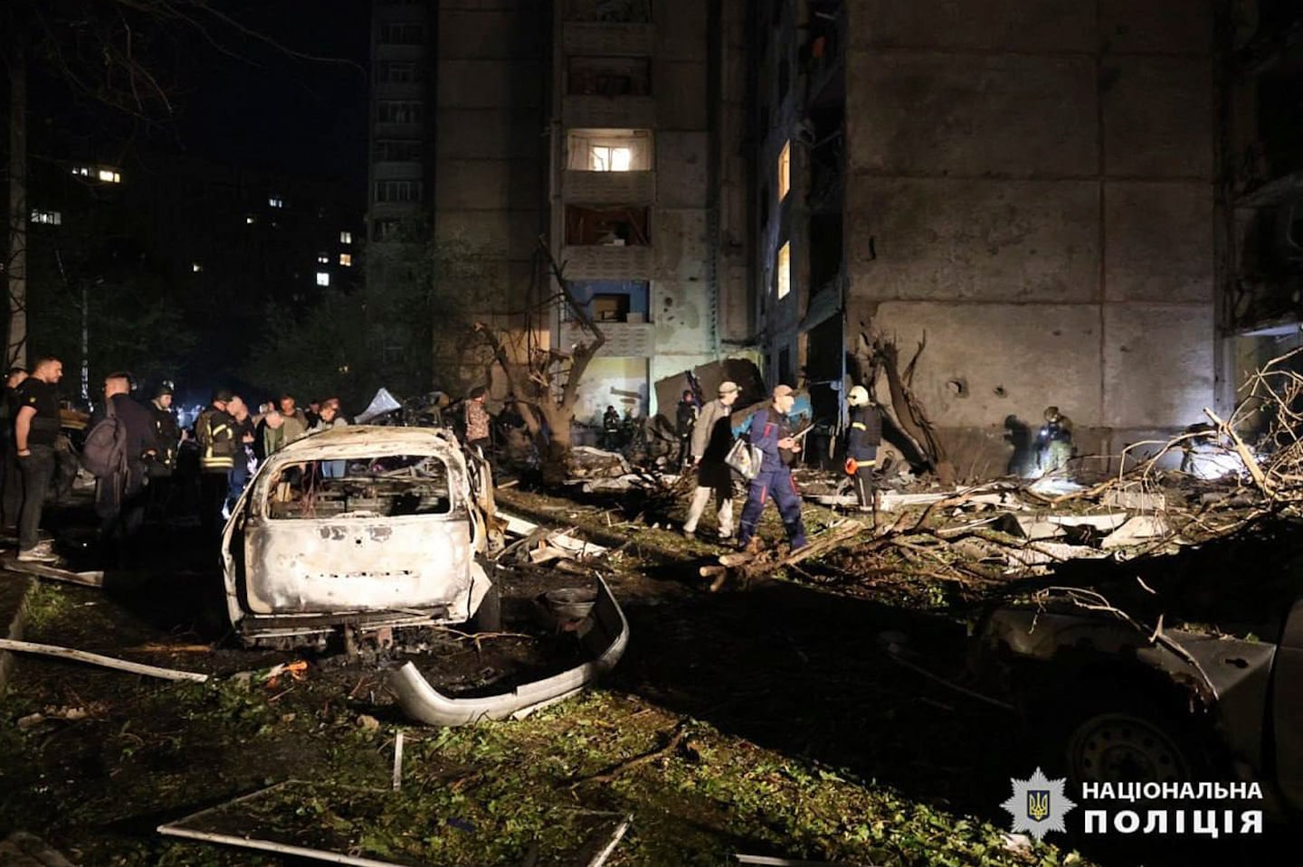 People mill around damaged cars and debris after a Russian strike on a residential building in Kharkiv, Ukraine, on Sept. 22.