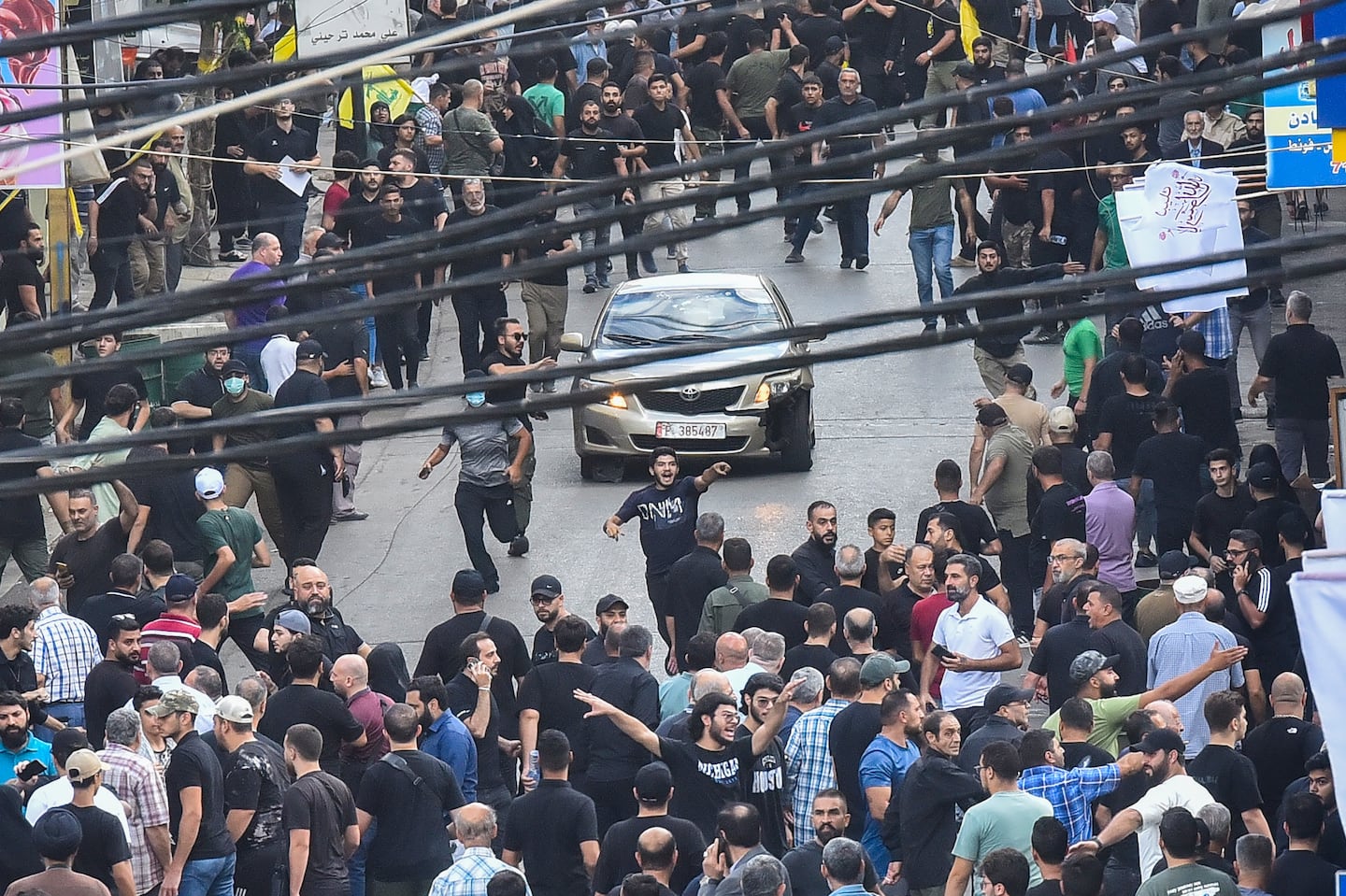 People reacted around a car after a reported explosion occurred during the funeral of those killed when hundreds of paging devices exploded across Lebanon the previous day, in Beirut's southern suburbs on Sept. 18.